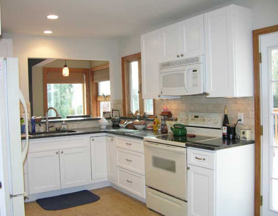 a bright kitchen with windows in the work area