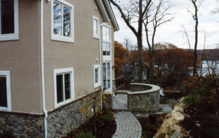 Small patio with curved rock wall, overlooking the lake beyond