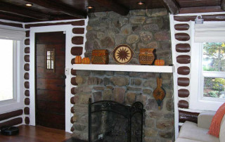 Original stone fireplace and exposed log walls